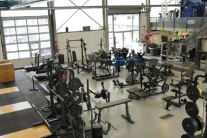 Blick in den Trainingsbereich des Friendship Gym in Hamburg mit Kraftgeräten, Hantelbänken und Cardioequipment.